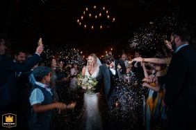 Newly married Bride and Groom at Hazel Gap Barn in Nottinghamshire, surrounded by joyous guests throwing confetti as they walk back down the aisle.